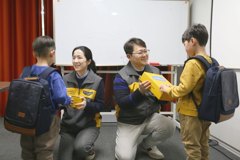 KB국민카드 직원들이 초등학교 입학을 앞둔 아동들에게 책가방을 전달하고 있다. KB국민카드 제공