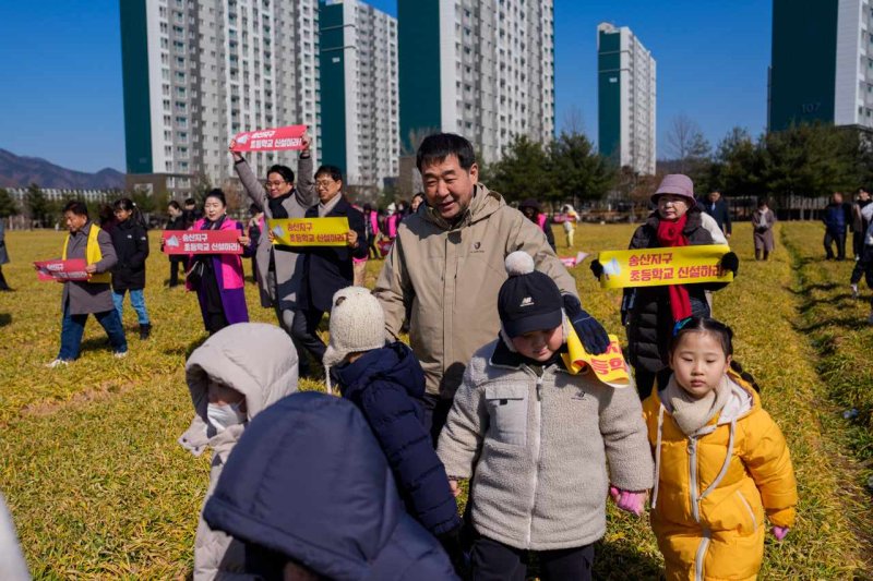 [증평=뉴시스] 20일 충북 증평군 증평읍 송산리에서 이재영(가운데) 군수와 초등학생들이 송산초등학교 신설을 기원하는 청보리밟기 행사를 진행하고 있다. (사진=증평군 제공) 2025.2.20. photo@newsis.com *재판매 및 DB 금지