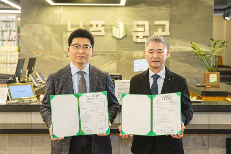 정성운 부산대병원장, 김필곤 남포문고 대표(왼쪽부터)가 협약식 후 기념촬영을 하고 있다. 부산대병원 제공