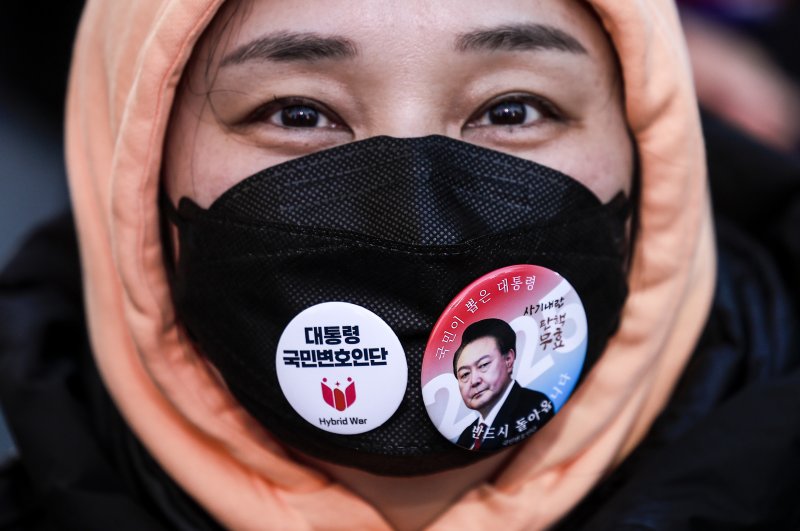 [서울=뉴시스] 정병혁 기자 = 13일 서울 중구 청계광장에서 열린 윤석열 대통령 국민변호인단 출범식에서 한 참가자가 윤 대통령 응원뱃지를 마스크에 달고있다. 2025.02.13. jhope@newsis.com