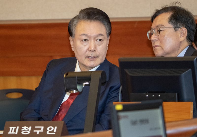 윤석열 대통령이 20일 오후 서울 종로구 헌법재판소 대심판정에서 열린 탄핵심판 10차 변론 기일에 출석해 변호인과 대화하고 있다. 2025.2.20/뉴스1 ⓒ News1 사진공동취재단