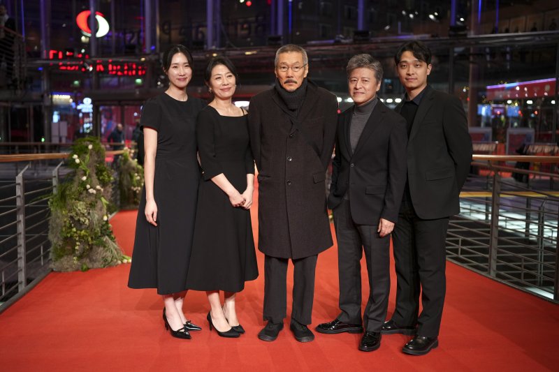 [베를린=AP/뉴시스] 홍상수(가운데) 감독이 20일(현지 시간) 독일 베를린에서 열린 제75회 베를린 국제영화제에서 영화 ‘그 자연이 네게 뭐라고 하니' 레드 카펫 행사에 참석해 출연진과 함께 포토 타임을 갖고 있다. 왼쪽부터 배우 강소이, 조윤희, 홍 감독, 권해효, 하성국. 임신 중인 김민희는 홍 감독과 베를린에 동행했으나, 공식 석상에는 서지 않았다. 2025.02.21.