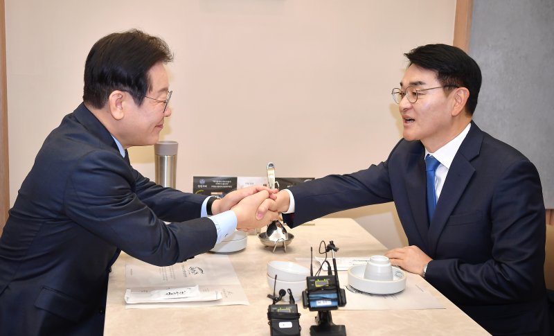 이재명 더불어민주당 대표와 박용진 전 의원이 21일 서울 여의도의 한 식당에서 만나 대화를 하던 중 악수하고 있다. (공동취재) 2025.2.21/뉴스1 ⓒ News1 안은나 기자