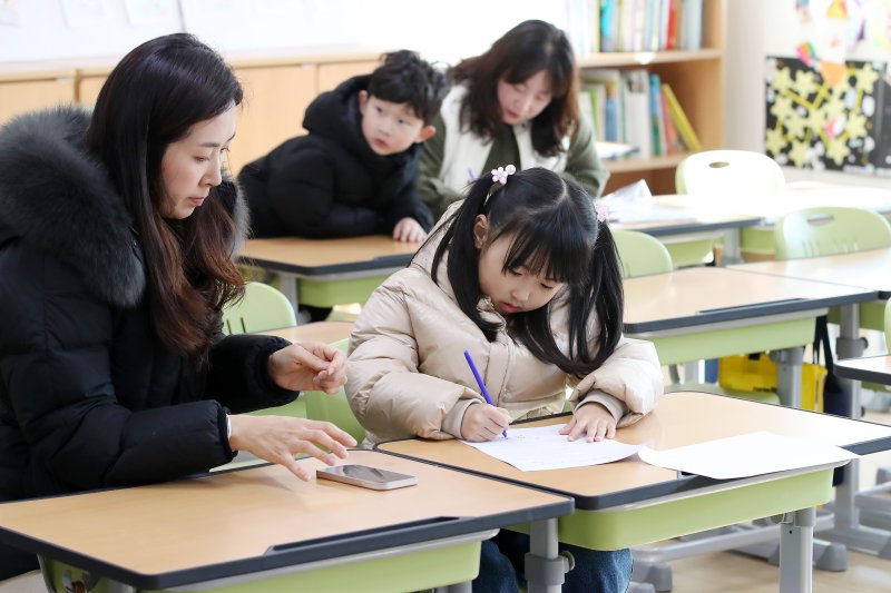 2025학년도 대구지역 초등학교 입학을 앞두고 신입생 예비소집이 진행된 2일 오후 대구 수성구 범어초등학교에서 엄마와 함께 학교를 찾은 어린이가 입학 서류에 이름을 적고 있다. 2025.1.2/뉴스1 ⓒ News1 공정식 기자