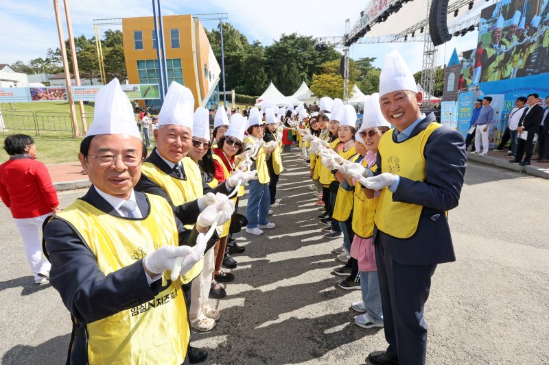 5일 전북자치도 임실군에서 치즈축제가 열리고 있는 가운데 심민 임실군수(왼쪽 첫번째)가 치즈를 늘리고 있다.(임실군제공)2024.10.5/뉴스1 ⓒ News1 김동규 기자