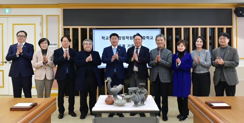 [창원=뉴시스]국립창원대 대학본부에서 열린 학교법인 창원학원 창원중학교의 유물 128점 기증식에 참석한 박민원(왼쪽서 다섯 번째) 총장, 창원학원 변성규 이사장 등이 기념촬영하고 있다.(사진=창원대 제공) 2025.02.24. photo@newsis.com