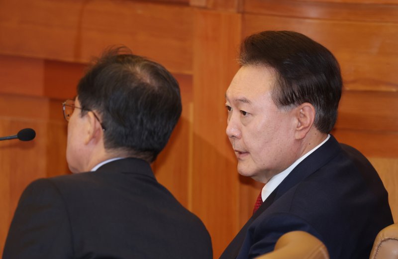 윤석열 대통령이 지난 20일 서울 종로구 헌법재판소에서 열린 탄핵심판 10차 변론에 출석해 윤갑근 변호사와 대화하고 있는 모습. 2025.2.20/뉴스1 ⓒ News1 사진공동취재단