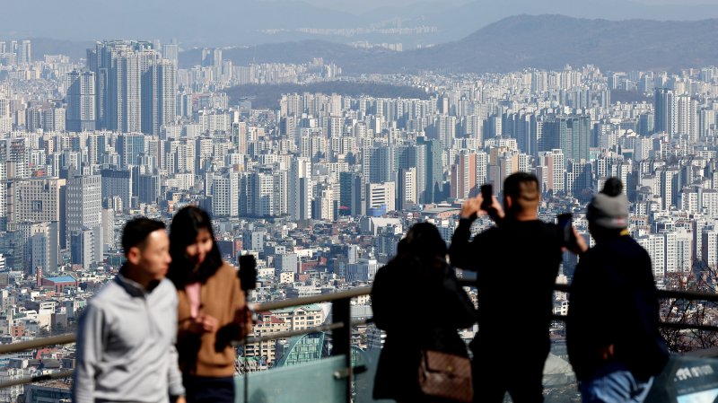 지난 21일 오후 서울 남산을 찾은 관광객들이 아파트 단지를 바라보고 있다. 부동산R114에 따르면 오는 3월 서울에서 성북구 장위동과 광진구 자양동 대단지의 입주가 본격 시작돼 업체 조사 기준 3월 역대 최대치인 5218가구가 입주할 전망이다. 2025.2.21/뉴스1 ⓒ News1 장수영 기자