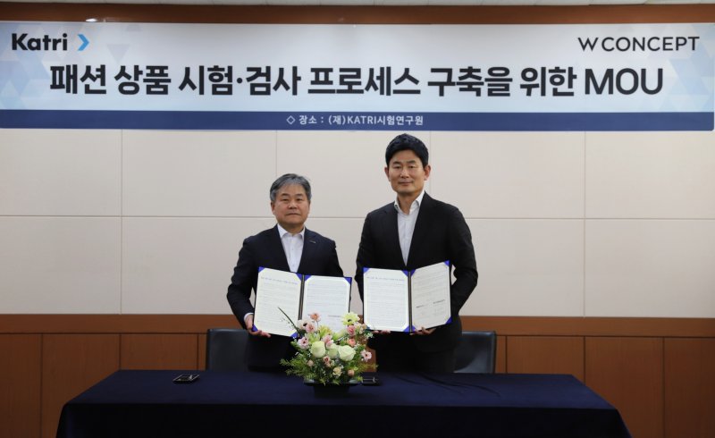 홍성수 W컨셉 지원담당(오른쪽), 신동준 KATRI시험연구원장이 '패션 상품 시험·검사 프로세스 구축을 위한 업무협약'을 체결한 뒤 기념 사진을 촬영하고 있다. W컨셉 제공