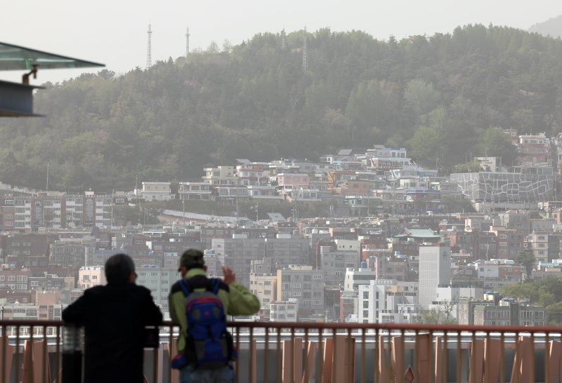 [부산=뉴시스] 하경민 기자 = 황사의 유입으로 부산 16개 구·군 모든 지역에 이틀째 '미세먼지(PM-10) 경보' 등이 발령된 18일 부산 중구 롯데백화점 광복점 옥상 전망대를 찾은 시민들이 뿌옇게 변한 도심을 바라보고 있다. 2024.04.18. yulnetphoto@newsis.com