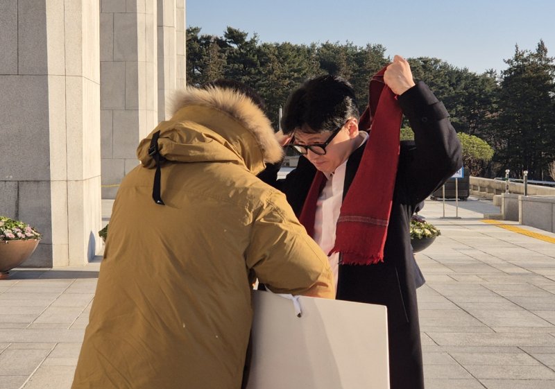 한동훈 국민의힘 대표가 2024년 12월 14일 오전 서울 여의도 국회에서 출근하며 윤석열 대통령 탄핵 표결 찬성 1인 시위 중인 김상욱 의원에게 자신의 목도리를 둘러주고 있다. (김상욱 의원실 제공) 2024.12.14/뉴스1