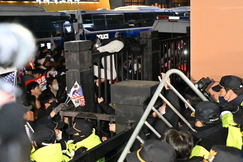 내란 우두머리 혐의로 체포된 윤석열 대통령의 영장실질심사가 열린 18일 오후 서울 마포구 서울서부지방법원에서 윤 대통령의 지지자들이 법원 담장에 가까이 붙어 규탄 집회를 하고 있다.(공동취재) 2025.1.18/뉴스1 ⓒ News1 민경석 기자