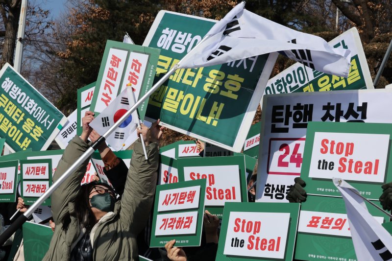 26일 오전 서울 서대문구 이화여대에서 윤석열 대통령 탄핵에 찬성하는 학생들과 반대하는 학생들이 뒤섞여 구호를 외치며 서로의 피켓을 가리고 있다. 2025.2.26/뉴스1 ⓒ News1 신웅수 기자