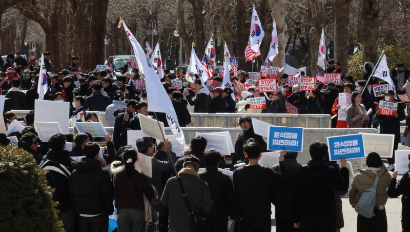 [인천=뉴시스] 전진환 기자 = 26일 오후 인천 인천 미추홀구 인하대학교에서 윤석열 대통령 탄핵 반대 측과 탄핵 찬성 측 지지자들이 피켓을 들고 마주하고 있다. 2025.02.26. amin2@newsis.com