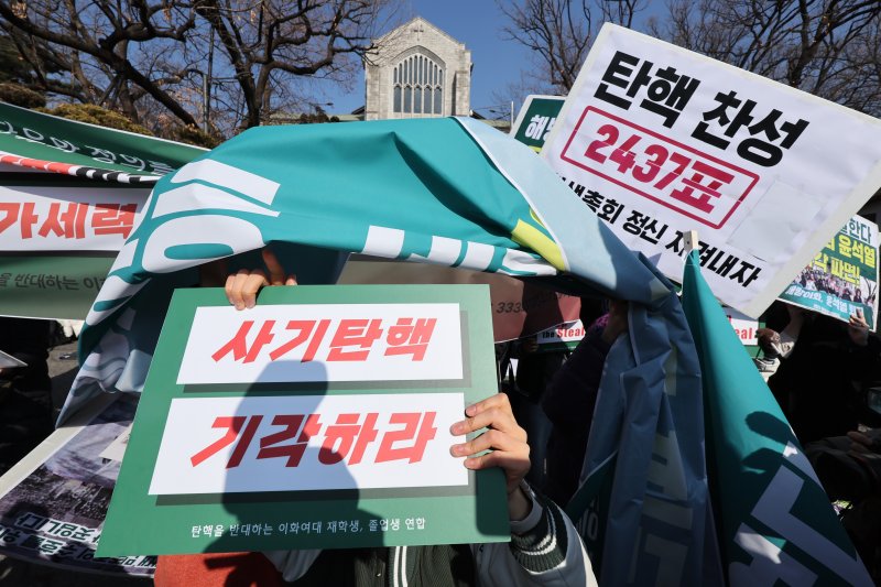26일 오전 서울 서대문구 이화여대에서 윤석열 대통령 탄핵에 찬성하는 학생들과 반대하는 학생들이 뒤섞여 구호를 외치며 서로의 피켓을 가리고 있다. 2025.2.26/뉴스1 ⓒ News1 신웅수 기자