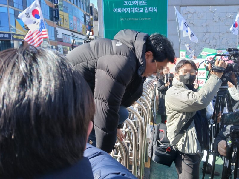 26일 오전 윤석열 대통령 탄핵 찬성·반대 집회가 열리는 서울 서대문구 이화여대에서 외부인이 담을 넘어 교내에 들어가고 있다. 2025.2.26/뉴스1 ⓒ News1 이강 기자