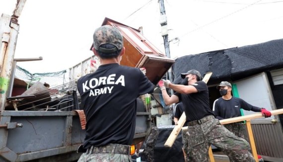 수해 복구 대민지원에 나선 군 장병들이 비에 젖어 못 쓰게 된 물건들을 정리하고 있다. 연합뉴스