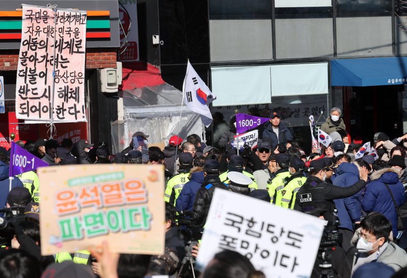 [부산=뉴시스] 하경민 기자 = 부산대학교 민주동문회, 윤석열퇴진금정비상행동 등 100여 명(사진 아래)이 24일 오후 부산 금정구 부산대 정문 앞에서 윤석열 대통령 탄핵반대 세력 규탄 기자회견을 연 가운데 탄핵반대 집회를 마무리한 보수단체 회원들이 도로를 사이에 두고 구호를 외치고 있다. 2025.02.24. yulnetphoto@newsis.com