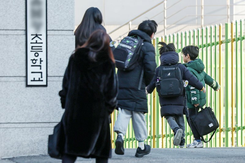 새학기부터는 늘봄학교가 기존 초등학교 1학년에서 2학년까지 확대됨에 따라 자녀의 귀가를 위해 학교를 찾는 학부모들이 더 많아질 전망이다. 서울의 한 초등학교에서 학부모들이 자녀의 등교를 배웅하고 있다. 2025.2.24/뉴스1 ⓒ News1 민경석 기자