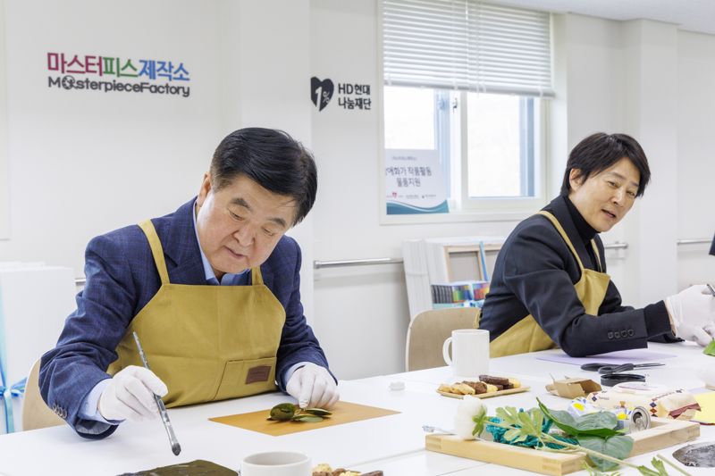 권오갑 HD현대1%나눔재단 이사장(왼쪽)이 27일 최수종 이사와 ‘마스터피스제작소’ 사업장을 찾아 미술 교육에 활용될 교보재를 직접 제작하고 있다. HD현대 제공