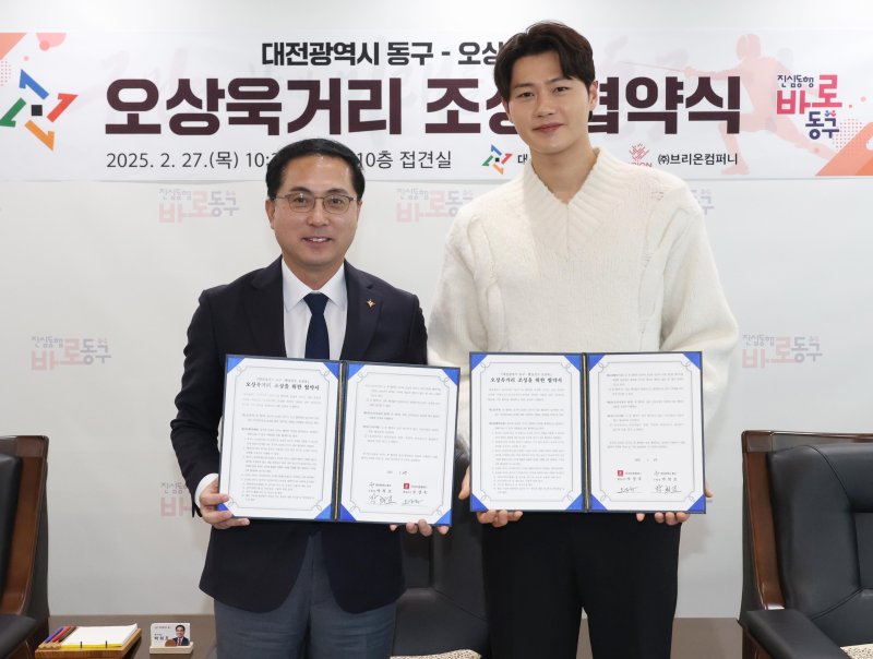 [대전=뉴시스] 조명휘 기자 = 박희조 대전 동구청장과 국가대표 펜싱선수 오상욱 선수가 27일 구청에서 '오성욱 거리' 명예도로 조성을 위한 업무협약을 맺고 있다. (사진= 동구청 제공) 2025.02.27. photo@newsis.com *재판매 및 DB 금지