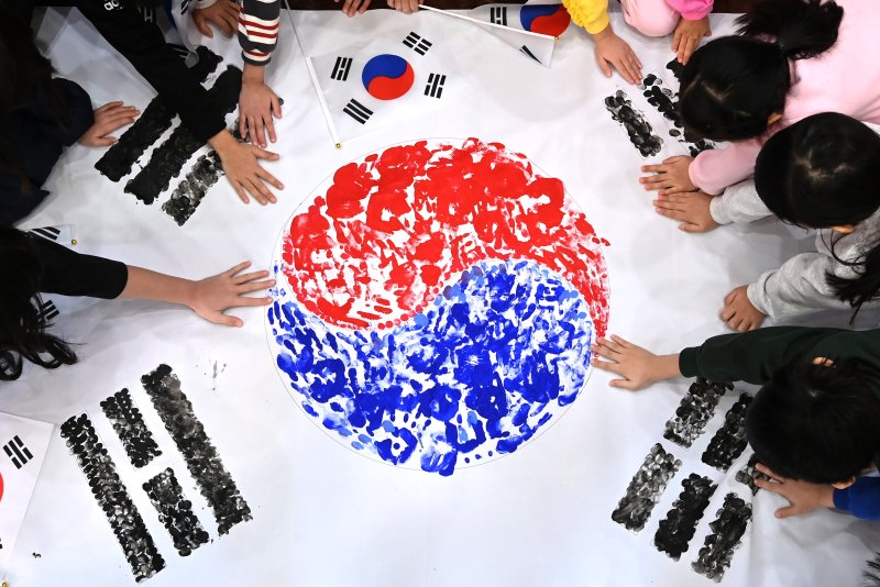 [수원=뉴시스] 김종택 기자 = 제106주년 삼일절을 이틀 앞둔 27일 경기도 수원시 세류1동 새마을문고 책먹는 아이들에서 열린 '나라사랑 한마음 손도장 태극기 만들기' 행사에서 어린이들이 물감으로 손도장 태극기를 그리고 있다. 2025.02.27. jtk@newsis.com
