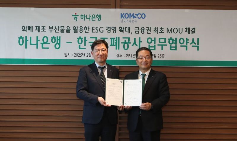 성창훈 한국조폐공사 사장(왼쪽)이 지난 27일 서울 중구 하나은행 본점에서 이호성 하나은행장과 ‘화폐 부산물을 활용한 ESG경영 활성화 협약’을 맺은 뒤 협약서를 들어 보이고 있다.