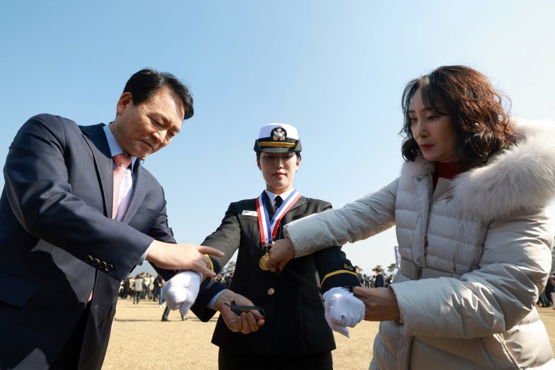 28일 충북 괴산군 육군학생군사학교에서 열린 '2025년 대한민국 학군장교 임관식'에서 제2연평해전 고 조천형 상사의 딸인 조시은 소위가 성일종 국회 국방위원회 위원장과 어머니로부터 계급장을 수여받고 있다. (사진= 국방일보 제공) 2025.02.28. /사진=뉴시스