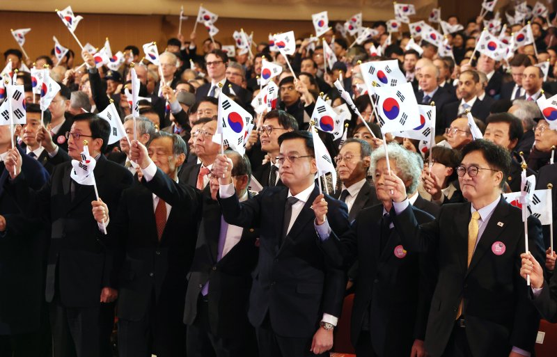 [서울=뉴시스] 조수정 기자 = 최상목 대통령 권한대행 부총리 겸 기획재정부 장관이 1일 서울 중구 숭의여자대학교에서 열린 제106주년 3·1절 기념식에서 독립유공자 후손 등 참석자들과 함께 태극기를 흔들고 있다. 오른쪽부터 우원식 국회의장, 정유헌 민족대표33인유족회 회장, 최 대통령 권한대행, 이종찬 광복회장, 독립운동가 고 오창근 선생 후손 오이환 씨, 독립운동가 고 노근우 선생 후손 강상준 씨. 2025.03.01. chocrystal@newsis.com