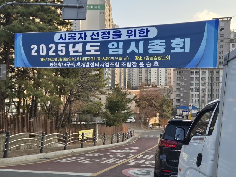 봉천14구역 재개발정비사업 지역 입구에 시공사 선정을 위한 임시총회 개최 안내 현수막이 붙어 있는 모습. 사진=연지안 기자