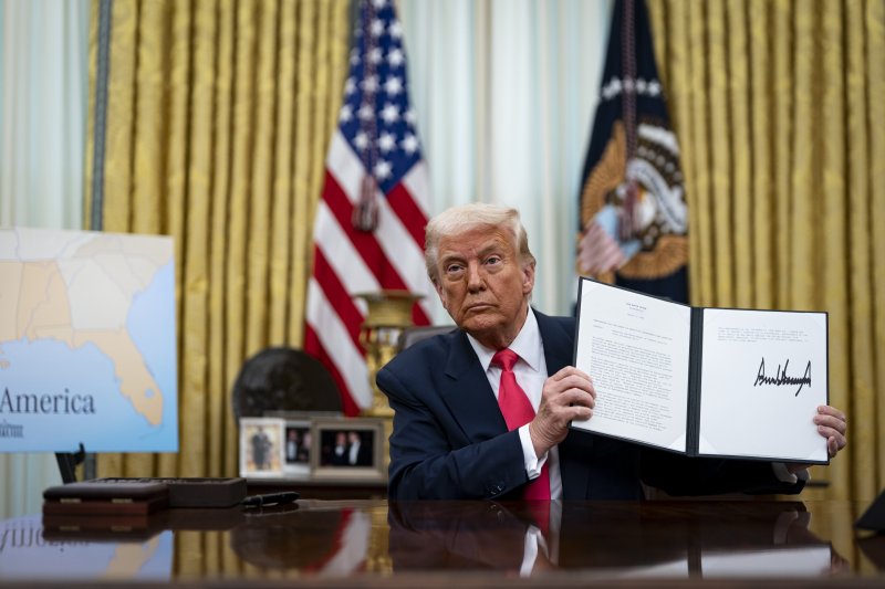 미국의 도널드 트럼프 대통령이 6일(현지시간) 워싱턴DC 백악관에서 행정명령에 서명한 뒤 이를 들어 보이고 있다.EPA연합뉴스
