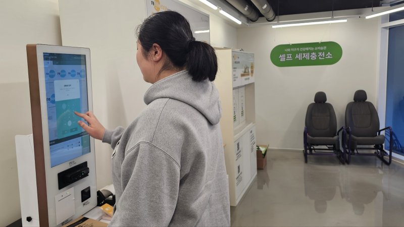 [광명=뉴시스]문영호 기자=광명동에 사는 박예윤씨가 7일 광명업사이클센터 지하1층에 설치된 셀프 세제충전소에서 섬유유연제를 충전하고 있다.2025.03.07.sonanom@newsis.com