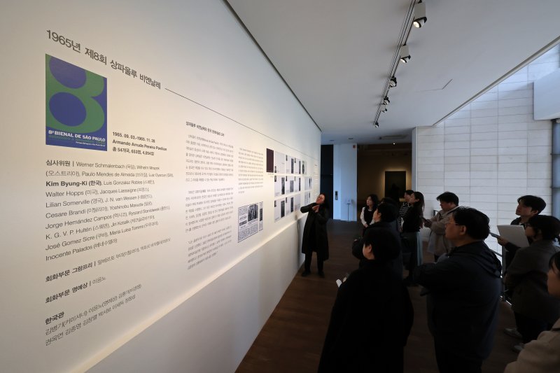 [서울=뉴시스] 박진희 기자 = 이보름 가나아트 전시 기획 총괄이 7일 서울 종로구 가나아트센터에서 열린 올해 첫 기획전 '김병기와 상파울로 비엔날레' 전시 작품 'Echo-1'(김환기 작가의 제8회 상파울로 비엔날레 출품작)을 설명하고 있다. 이번 전시는 작고한 태경 김병기(1916-2022)의 3주기를 기념하며, 그가 커미셔너이자 심사위원으로 활동했던 1965년 제8회 상파울로 비엔날레의 60주년을 맞아 한국 현대미술이 국제 무대에 본격적으로 진출했던 역사적 순간을 조명하는 뜻깊은 전시이다. 2025.03.07. pak7130@