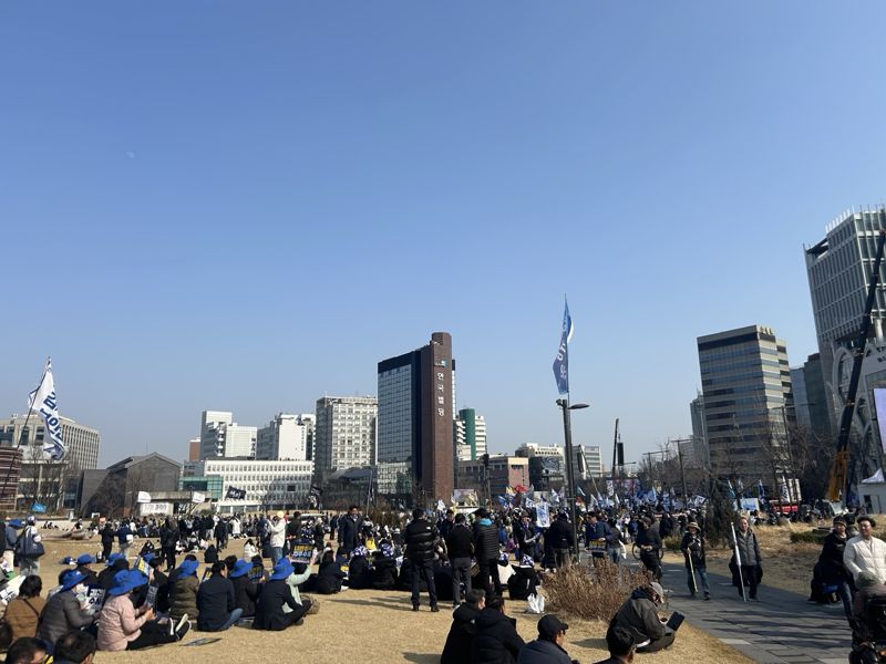 안국동 사거리 송현공원에서 열린 '윤석열 파면·국힘당 해산 130차 전국집중 촛불문화제' 참석자들이 잔디밭에 앉아 있다. 사진=강명연 기자