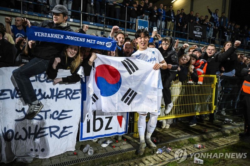 태극기를 들고 팬들과 기뻐하는 오현규 (출처=연합뉴스)