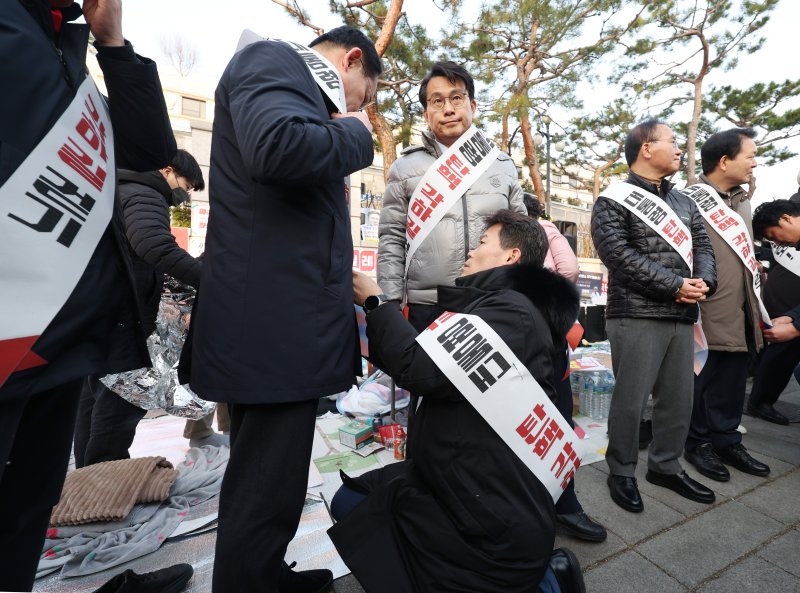 [서울=뉴시스] 김진아 기자 = 한국사 강사 전한길 씨가 국민의힘 기독인회 의원들과 14일 서울 종로구 헌법재판소 앞에서 '탄핵 각하 길' 걷기 기자회견에 앞서 어깨띠를 두르고 있다. 2025.03.14. bluesoda@newsis.com