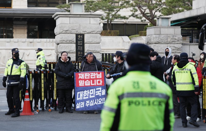 [서울=뉴시스] 김진아 기자 = 윤석열 대통령 탄핵 심판 선고를 앞둔 14일 서울 종로구 헌법재판소 앞에 윤 대통령 지지자들이 손팻말을 들고 있다. 2025.03.14. bluesoda@newsis.com