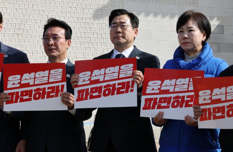 박찬대 더불어민주당 원내대표(가운데)와 김민석(왼쪽), 전현희 최고위원이 14일 서울 광화문 앞에서 열린 현장 최고위원회의에서 피켓을 들고 윤석열 대통령 파면을 촉구하고 있다. 2025.3.14/뉴스1 ⓒ News1 박세연 기자