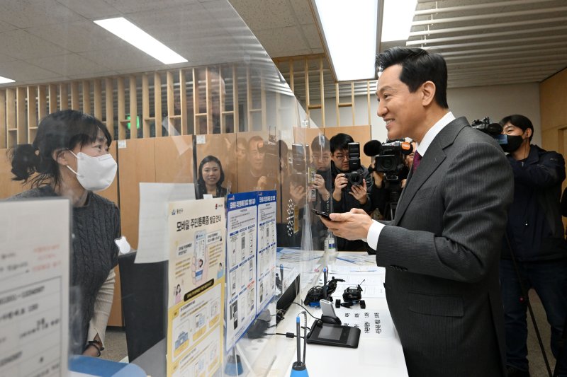 [서울=뉴시스] 고범준 기자 = 오세훈 서울시장이 14일 서울 용산구 남영동 주민센터에서 모바일 주민등록증을 발급 받고 있다. 2025.03.14. (공동취재) photo@newsis.com