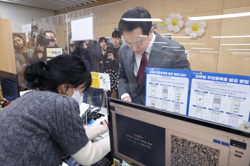 [서울=뉴시스] 고범준 기자 = 오세훈 서울시장이 14일 서울 용산구 남영동 주민센터에서 모바일 주민등록증을 발급 받고 있다. 2025.03.14. (공동취재) photo@newsis.com
