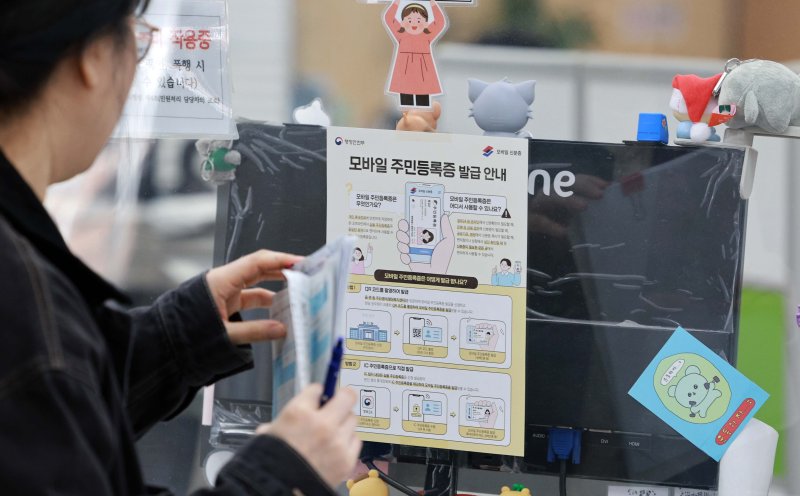 [서울=뉴시스] 고범준 기자 = 전국에서 모바일 주민등록증 발급이 시작된 14일 서울 용산구 남영동 주민센터에 모바일 주민등록증 발급 관련 안내문이 붙어 있다. 전국 어디서든 등록 주소지 관할 기초 지방자치단체 주민센터에서 모바일 주민등록증을 신청할 수 있고, 오는 28일부터는 주소지와 상관없이 모든 주민센터 및 온라인에서도 모바일 주민등록증을 신청할 수 있다. 2025.03.14. bjko@newsis.com
