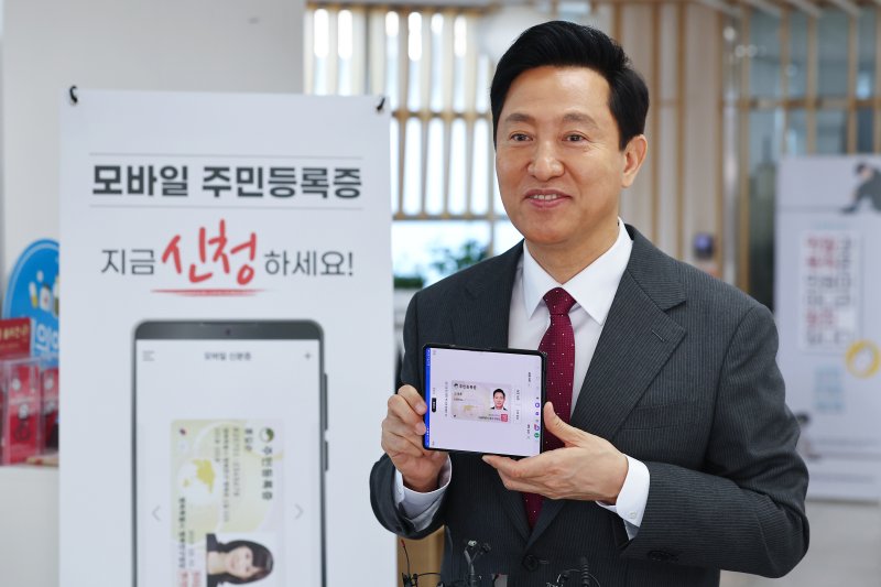 [서울=뉴시스] 고범준 기자 = 오세훈 서울시장이 14일 서울 용산구 남영동 주민센터에서 모바일 주민등록증을 발급 받고 기념촬영을 하고 있다. 2025.03.14. (공동취재) photo@newsis.com