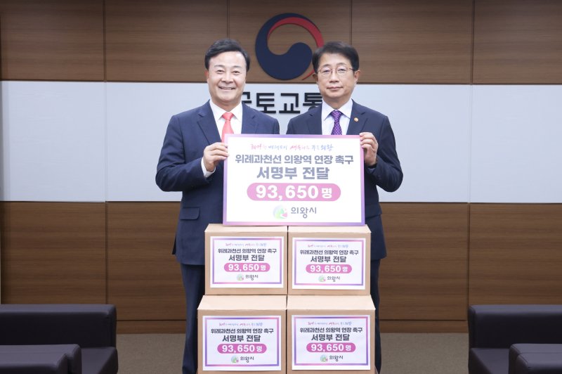 [의왕=뉴시스] 김성제 의왕시장(사진 왼쪽)이 박상우 국토부 장관에게 의왕시민 9만3650명이 서명한 명부를 전달하고 있다. (사진=의왕시 제공). 2025.03.14.photo@newsis.com