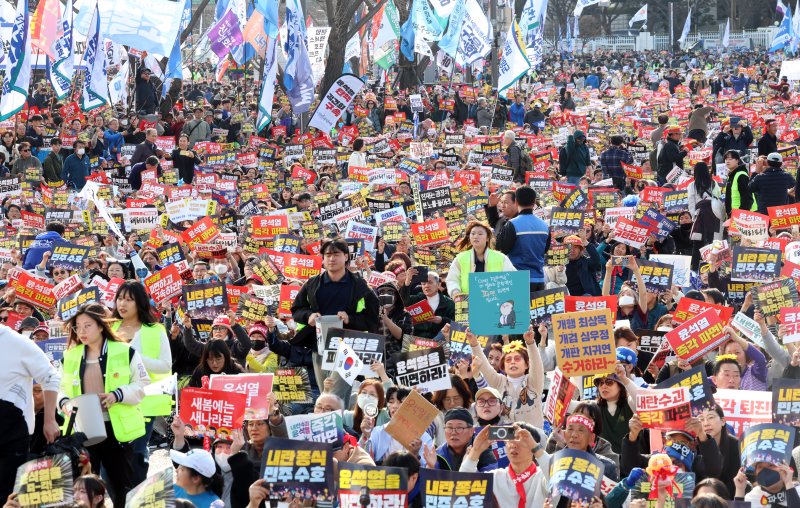 15일 서울 종로구 사직로에서 열린 '윤석열즉각퇴진·사회대개혁 비상행동 대행진'에서 참가자들이 피켓을 들고 구호를 외치고 있다. 2025.3.15/뉴스1 ⓒ News1 김명섭 기자