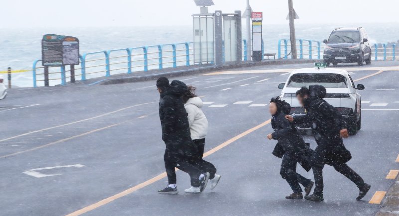 제주시 용담동 해안도로에서 관광객들이 눈발을 피해 급히 발걸음을 옮기고 있다. 2025.1.9/뉴스1 ⓒ News1 오현지 기자