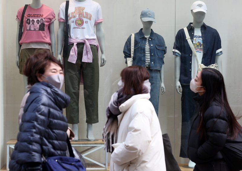 삼일절 연휴기간 전국적으로 눈·비가 내리며 짧은 꽃샘추위가 찾아온 3일 서울 명동거리에서 두터운 옷을 입은 관광객이 봄옷이 걸린 쇼윈도를 지나가고 있다. 2025.3.3/뉴스1 ⓒ News1 이동해 기자