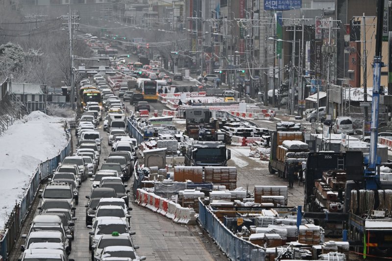 [광주=뉴시스] 이영주 기자 = 절기상 춘분을 이틀 앞둔 18일 오전 광주 남구 백운광장 주변 도로가 내린 눈에 얼어붙은 빙판길과 광주도시철도2호선 공사로 정체 현상을 빚고 있다. 2025.03.18. leeyj2578@newsis.com