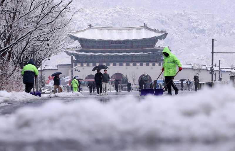 난데없는 3월 대설주의보가 발효된 18일 오전 서울 광화문광장에서 관계자들이 눈을 치우고 있다. 2025.3.18/뉴스1 ⓒ News1 박지혜 기자