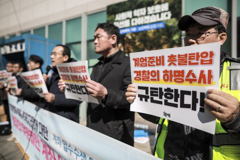 [서울=뉴시스] 정병혁 기자 = 19일 서울 종로구 서울경찰청 앞에서 열린 촛불행동 회원, 후원자들에 대한 계좌 압수수색 2차 공동 고소 고발 기자회견에서 촛불행동 회원들이 피켓을 들고 있다. 2025.03.19. jhope@newsis.com