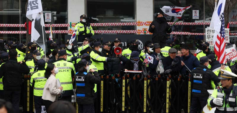 [서울=뉴시스] 홍효식 기자 = 윤석열 대통령 탄핵 심판 선고 발표가 늦어지고 있는 20일 오전 서울 종로구 헌법재판소 앞에서 경찰들이 탄핵 반대 시위자가 던진 계란 및 바나나가 1인 시위를 벗어난 행태라며 강제 해산을 시도하고 있다. 2025.03.20. yesphoto@newsis.com